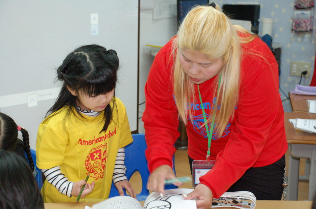 先生と英語でコミュニケーションを取るプリスクールの子ども